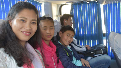 En kvinna och hennes barn sitter på en buss.