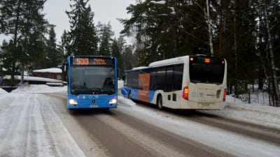 Två bussar som kör förbi varandra i Grankulla. 
