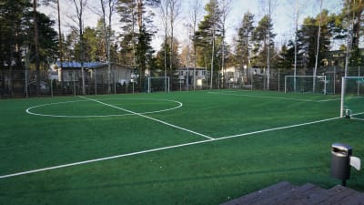 Inhägnad fotbollsplan på en skolgård.