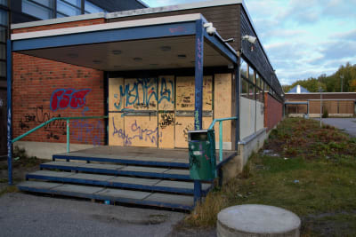skolbyggnad i tegel som vandaliserats med graffiti.