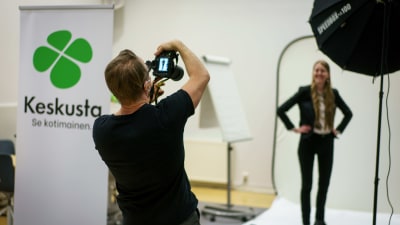 Fotograf fotograferar en av Centerns kandidater i en tillfällig fotostudio.