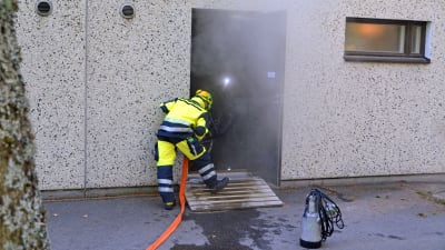 Brandman som jobbar med att pumpa ut vatten.