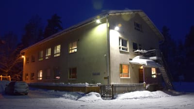 En beige skolbyggnad omringad av snö. På väggen står det Svartå skola.