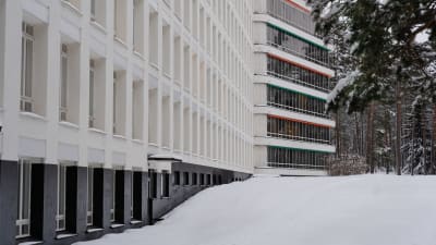 Paimion parantola kuvattuna helmikuussa illansuussa. Lunta on runsaasti, ikkunoiden yläpuolella oranssit ja vihreät markiisit.