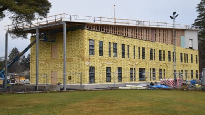 Ett två våningar stort hus byggs, ställningar på taket, gul isolering på väggarna.