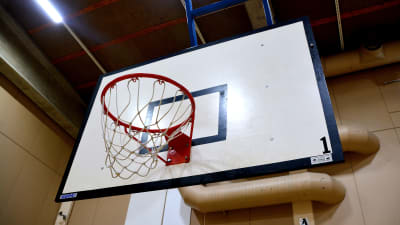 Basketkorg i idrottshall.