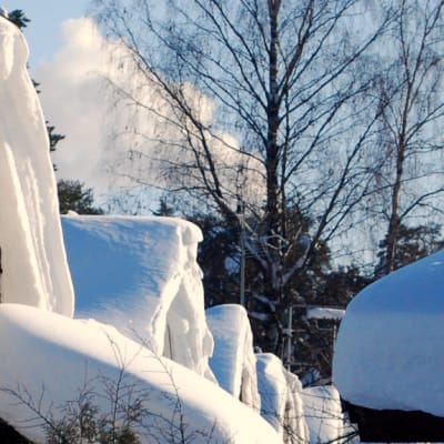 Lumisia omakotitalojen kattoja Kuopion Niiralassa.
