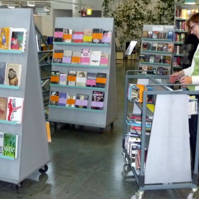 Kirjastotoimenjohtaja Rebekka Pilppula selaa kirjoja aulatilassa.