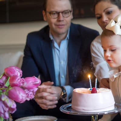 2-vuotias prinsessa Estelle ja hänen vanhempansa syntymäpäiväkakun äärellä.