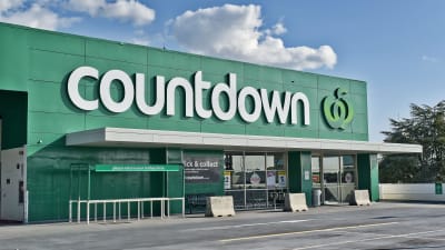 En mataffär med namnet Countdown i Auckland, Nya Zeeland. Ovanom huvudingången syns logon, vilket består av texten "Countdown" och ett äpple. Affärens väggar är gröna.