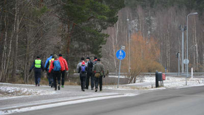 En grupp människor promenerar på en lättrafikled.
