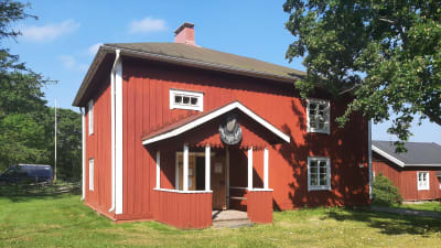 Röd träbyggnad i två våningar.
