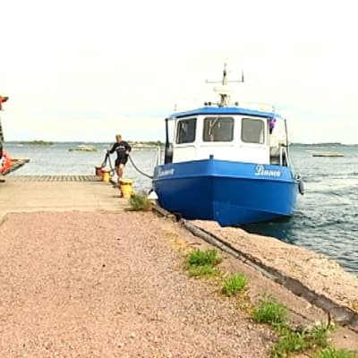 Vene laiturissa ja ihmisiä.