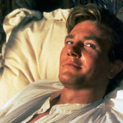 Nuori mies (Albert Finney) sängyssä hymyilee nojatessaan päätään tyynyyn.