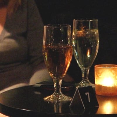En tjej sitter bredvid två glas öl.