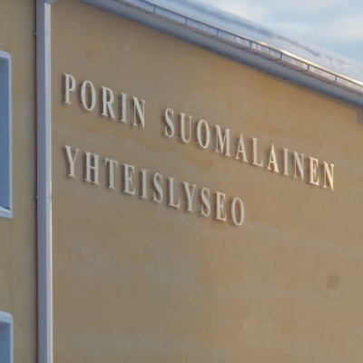 Seinä, jossa lukee "Porin suomalainen yhteislyseo". Katolla lunta.