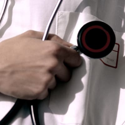 En läkare som håller i ett stetoskop.