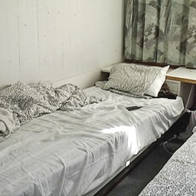 Kuvassa kahden sängyn huone, jossa muuta liikkumatilaa on erittäin vähän.