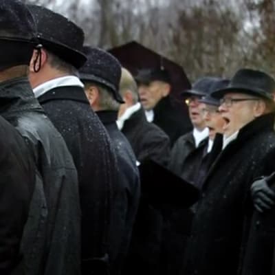 Mieskuoro laulaa Helsingin Tähtitorninmäellä.