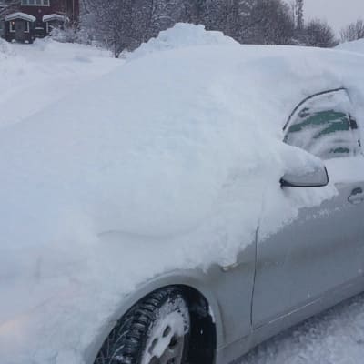 Lumen peittämä auto.