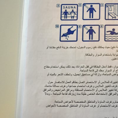 Vieraskieliset ohjeet uimahallissa kävijälle. 