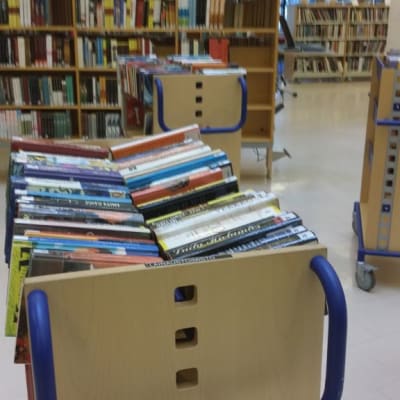 Kirjoja palautuskärryssä kirjastossa