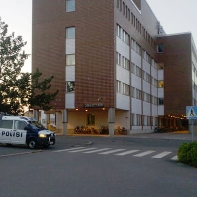 Poliisiauto Oulun oikeustalon edustalla myöhään sunnuntaina 28. heinäkuuta 2013. Poliisitalo on rakennuksen toisessa päässä, ja rakennuksen takana on parkkipaikka, jossa poliisi piiritti aseitautunutta miestä sunnuntai-iltana. 