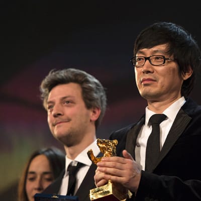 Elokuvaohjaaja Diao Yinan (kesk.), sekä näyttelijä Liao Fan (oik.) palkittiin Berlinalessa 15. helmikuuta 2014. Kuvassa oikealla myös ranskalaiset elokuvantekijät Caroline Poggi (vas.) ja Guillaume Caillau.