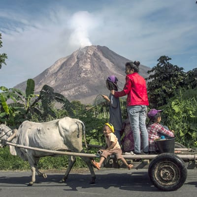 Indonesialainen perhe ohittaa Sinabungin tuolivuoren Karossa