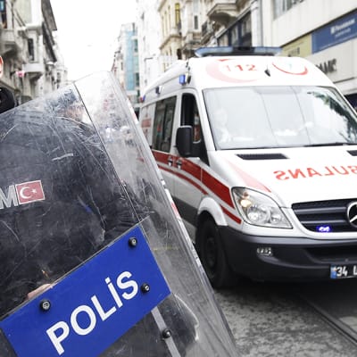Poliisi ohjaa ambulanssia pommi-iskun tapahtumapaikalta Istanbulissa.