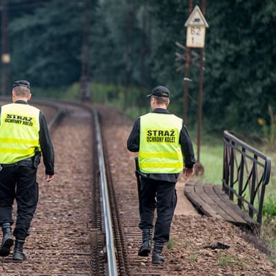 Kaksi poliisia vartijaa junaraiteilla.