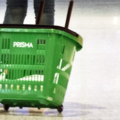 Asiakas vetää ruokakoria perässään ruokakaupassa.