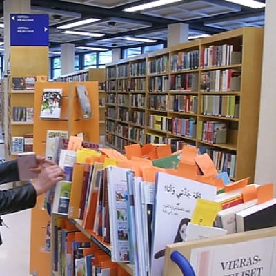 Fereshte Khodadadi selailee kirjoja Porin kirjastossa