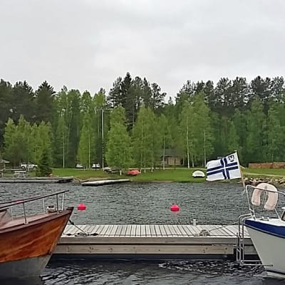 Venesatama jossa kaksi venettä, taustalla veneilijöiden tukikohta