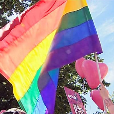 Sateenkaarilippu liehuu Oulun Pride-paraatissa.