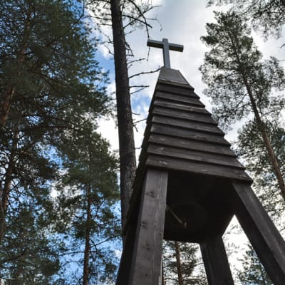 Ristitorni puiden keskellä.