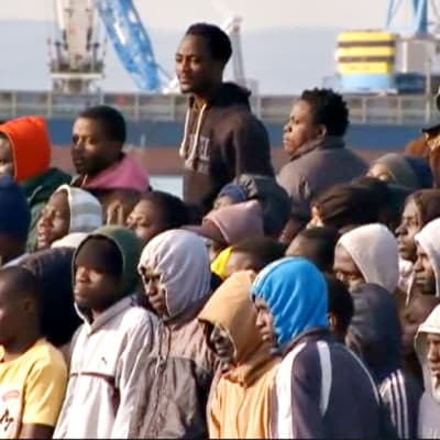 Pakolaisia laivan kannella Sisiliassa.