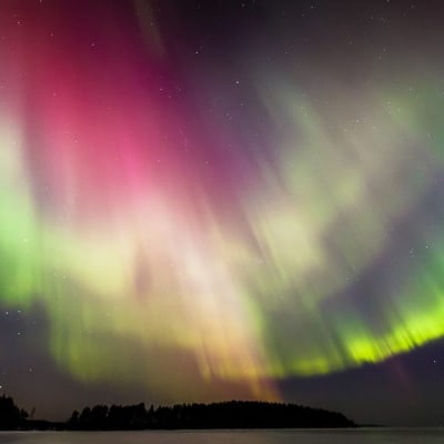 Taipalsaarelainen luontokuvaaja ikuisti näyttävät revontulet Saimaan yllä.