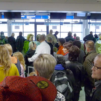 Ihmisiä jonottaa tiskeille Joensuun lentoasemalla.