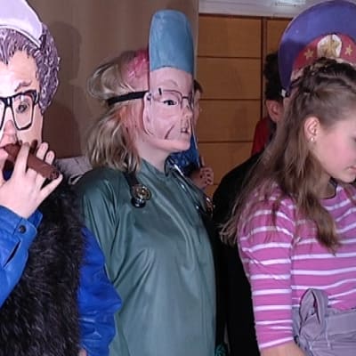 Nuoret seisovat naamait päässä näytelmässä
