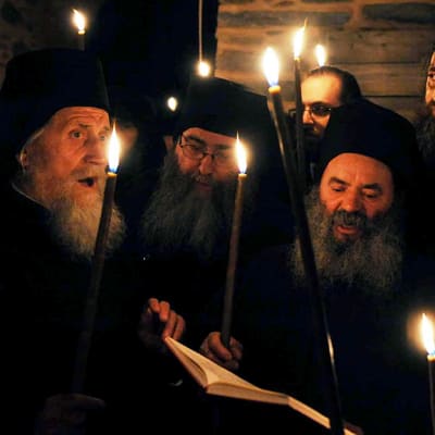 Ortodoksimunkit pääsiäisyön jumalanpalveluksessa Athosvuorella.