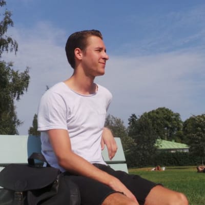 Nuori mies istuu puistonpenkillä Porin Kirjurinluodossa