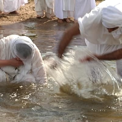 Miestä kastetaan vedessä