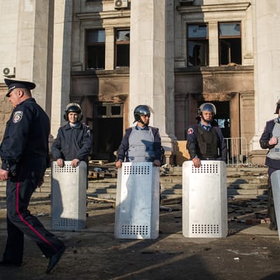 Ukrainalaiset poliisit vartioivat Odessassa palaneen ammattiliittorakennuksen edustalla.
