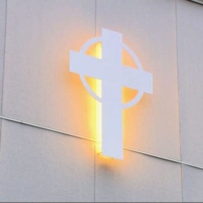 Risti loistaa kirkon seinässä