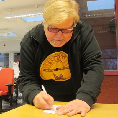 Kuvassa Jussi Raittinen kirjoittaa nimikirjoitusta
