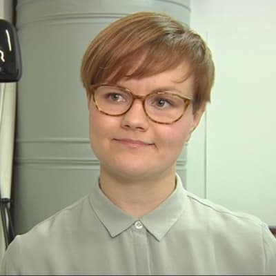 Muotoilija Katriina Nuutinen suunnittelemiensa valaisimien vierellä. 