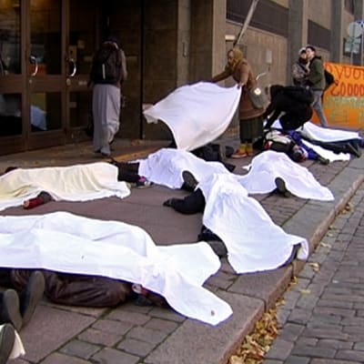 ihmisiä makaa kadulla lakanoilla peitettynä