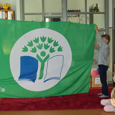 Lapset pitelevät vihreää lippua.