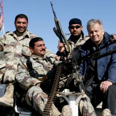 Rauli Virtanen istuu kolmen henkivartijan kanssa auton lavalla Irakissa.
